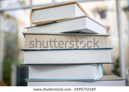 Stack of various books on a table, representing education, reading, and knowledge in a bright and airy environment. textbooks as tools can help improve your intellect and expand your knowledge