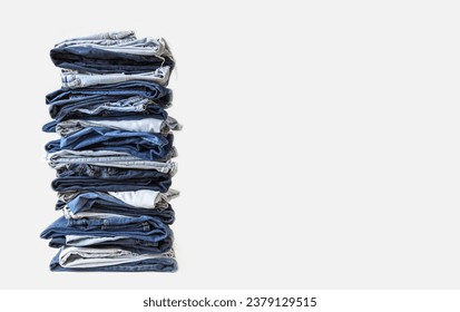 Stack of various shades of blue jeans on white background. Lots of jeans pants in a stack. The concept of buying, selling, shopping and trendy modern clothes. - Shutterstock ID 2379129515