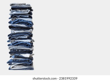 Stack of various shades of blue jeans on white background. Lots of jeans pants in a stack. The concept of buying, selling, shopping and trendy modern clothes. - Shutterstock ID 2381992339