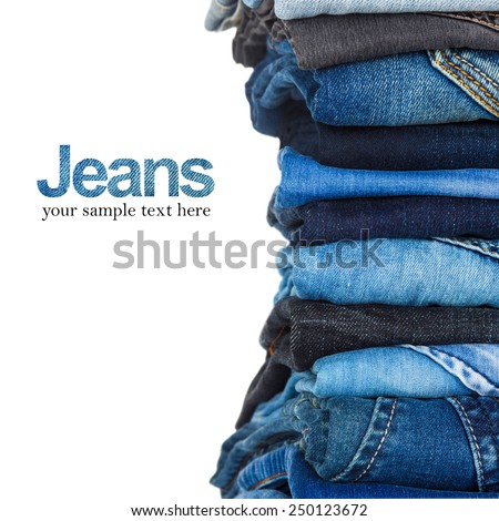 stack of various shades of blue jeans on white background
