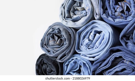 Stack Of Various Shades Of Rolled Up Denim Jeans Background Banner Texture. 