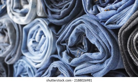 Stack Of Various Shades Of Rolled Up Denim Jeans Background Banner Texture. 