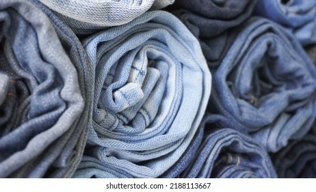 Stack Of Various Shades Of Rolled Up Denim Jeans Background Banner Texture. 