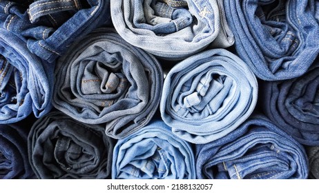 Stack Of Various Shades Of Rolled Up Denim Jeans Background Banner Texture. 