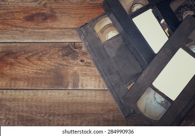  Stack Of VHS Video Tape Cassette Over Wooden Background. Top View Photo