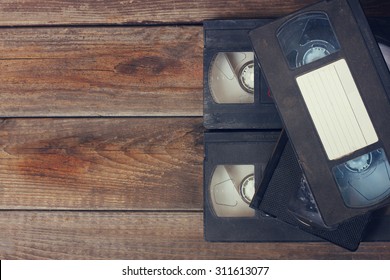 Stack Of VHS Video Tape Cassette Over Wooden Background. Top View Photo
