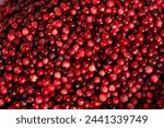 A stack of vibrant cranberries neatly arranged on a wooden table.