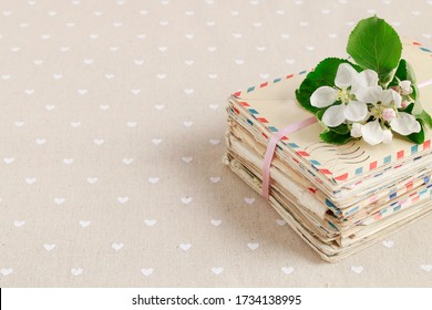 Stack of vintage love letters and apple tree flowers.