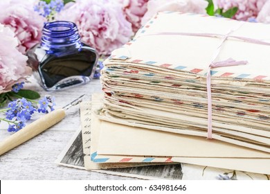 Stack Of Vintage Love Letters And Pink Peonies In The Background. 