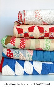 A Stack Of Vintage Patchwork Quilts