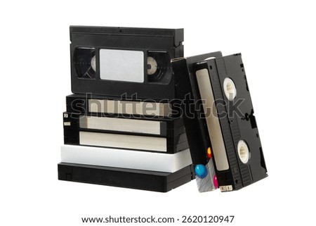 Stack of vintage VHS tapes on white background, retro video cassettes collection with labels and colorful designs.