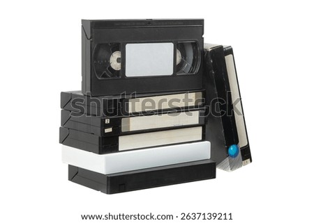 Stack of vintage VHS tapes on white background, retro video cassettes collection with labels and colorful designs.