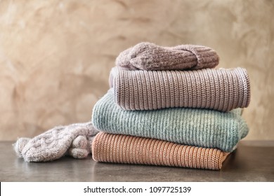 Stack Of Warm Knitted Clothes On Table