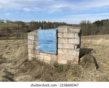 A Stack Of Weathered Hollow Blocks With Blue Sack In The Field