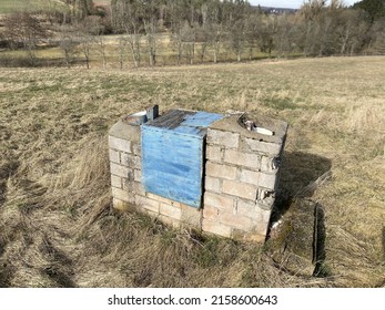 A Stack Of Weathered Hollow Blocks With Blue Sack In The Field