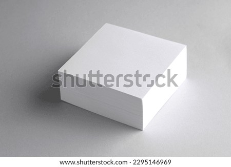 Stack of white blank square memo papers on gray background
