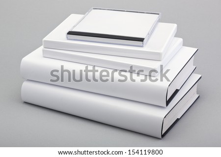 Stack of white books with dvd and cd covers ready for artwork covers and spines