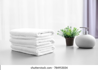 Stack Of White Clean Towels On Table In Bathroom