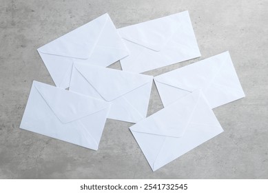 a stack of white envelope scattered on a grey background.