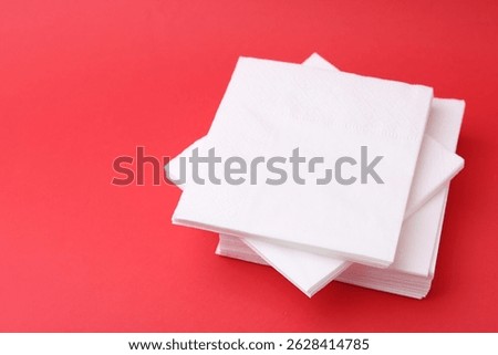 Stack of white handkerchiefs on red background, closeup. Space for text