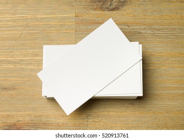 Stack Of White Not Aligned Business Cards On A Brown Wooden Table