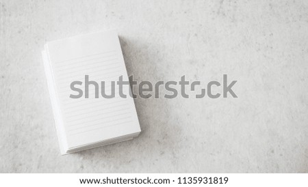 Stack of white notepapers on white table