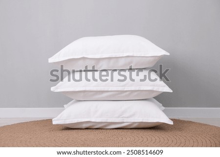 Stack of white pillows on floor indoors