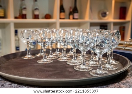 Stack of white plates and empty wine glasses