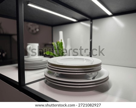 Stack of White Plates on Modern Kitchen Shelf with LED Lighting