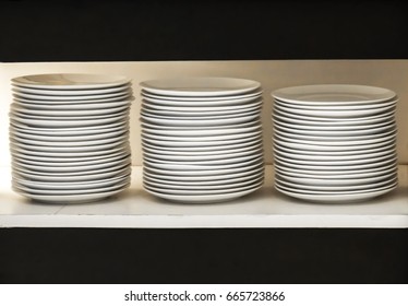 Stack of white plates on the showcase with copy space. Restaurant utensils. shallow focus.