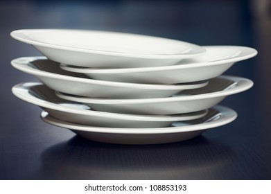 A Stack Of White Plates On A Table