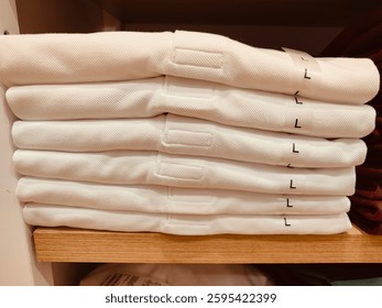 A stack of white shirts with the letters L and L on them. The shirts are neatly stacked on top of each other - Powered by Shutterstock - Get 15% off with code: PIKWIZARD15
