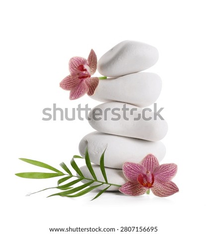 Stack of white spa stones with pink orchids and green leaf