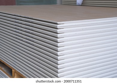 The stack of WHITE Standard Gypsum board panel. Plasterboard. Panel Type A designed for indoor walls, partitions and ceilings, construction site