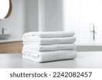 Stack of white towels on table in bathroom