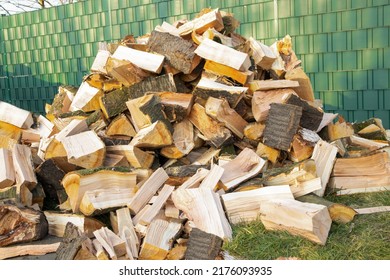 Stack Of Wood, Chopped Lie Stacked On The Street. Preparation For The Winter For The Stove, Fireplace. The Concept Of Fuel, Fire, Heat In Winter, Expensive Gas, Heating, Biofuel High Quality Photo