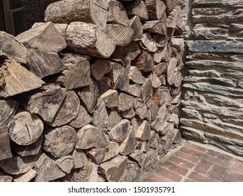 Stack of Wood next to Stone Wall