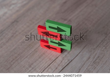 A stack of wooden blocks with arrows are pointing in opposite directions. Contradiction, different perspective concept.