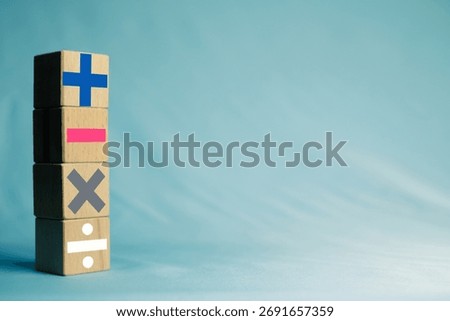 A stack of wooden blocks with mathematical plus, minus, multiply,divide icon.Concept for financial calculation, business decision-making (pros and cons), basic mathematics education, or accounting.