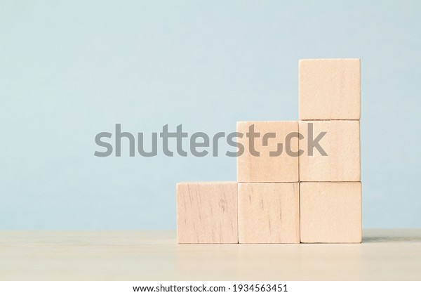 Stack wooden blocks on\
a blue background