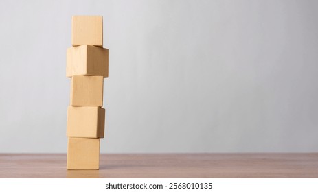 Stack of wooden blocks on a wooden surface on a grey background