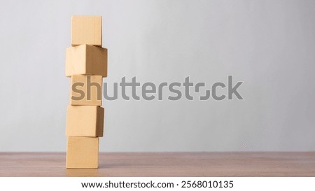 Stack of wooden blocks on a wooden surface on a grey background