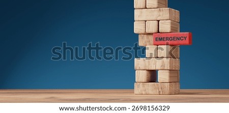 Stack of wooden blocks with one red block labeled EMERGENCY representing crisis, danger, or instability. Concept of emergency planning, risk management, crisis response, and finance safety.