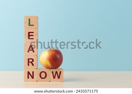 Stack of wooden blocks spelling LEARN and a block with NOW beside it, with a red apple on top. The image suggests themes of education, immediacy and skill development. Invest in yourself