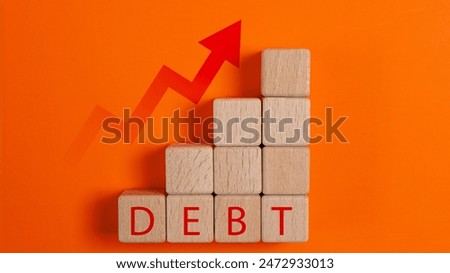 A stack of wooden blocks with the word debt written on them. The blocks are arranged in a way that they form a pyramid shape, with the word debt written at the top