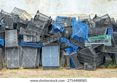 Stack of wooden and plastic vegetable crates, showing textures, colors, and rustic market or storage atmosphere. Perfect for agriculture, market, or logistics projects.