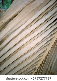 A stack of worn, aged cardboard sheets stacked haphazardly, with visible signs of wear and tear, suitable for use as a background or texture in design projects emphasizing sustainability and eco-friendliness.
