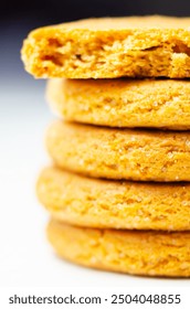 A stack of yellow cookies with a white background. The cookies are piled on top of each other, creating a visually appealing and appetizing display