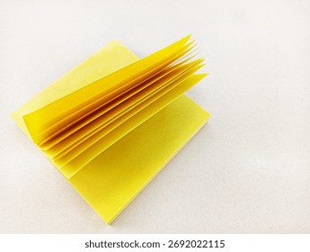 Stack of yellow sticky notes with open pages on white background