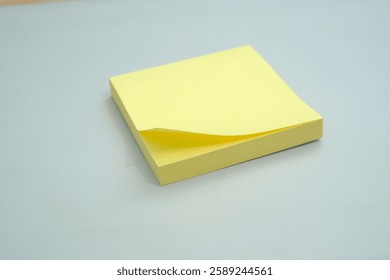Stack of yellow sticky notes surrounded by several crumpled pieces of paper on a clean, light surface, representing brainstorming, creativity, problem-solving, and the process of working through ideas